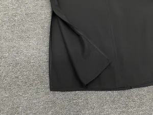 Detail shot of a minimalist black top featuring a clean side slit and refined stitching