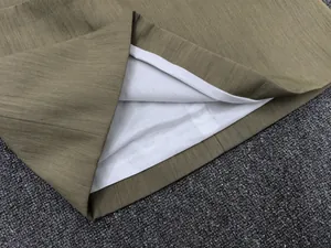 Detailed close-up showing olive green textured fabric hem with white inner lining stitching