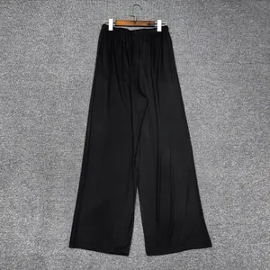 Détail d'un pantalon large noir minimaliste avec taille élastique sur un cintre