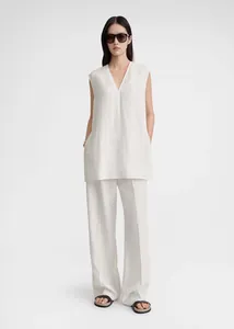 Detail of white linen V-neck sleeveless top with side slits and wide-leg trousers set