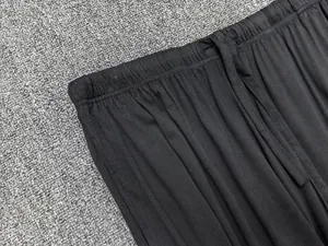 Détail de la taille élastique à cordon sur le pantalon large noir en tissu souple