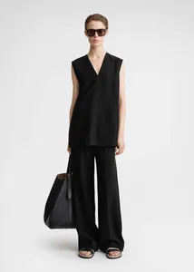 Close-up of minimalist black sleeveless V-neck top with high side slits and cotton texture