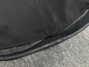 Close-up of the smooth hem and premium stitching on a black satin sleeveless top