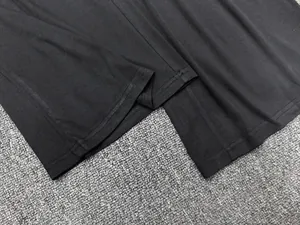 Détail macro du pantalon en coton noir montrant la précision de la double couture plate