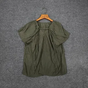 Detail of olive green short sleeve top featuring fine vertical pleated texture and drawstrings