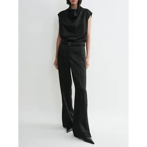 Minimalist black satin sleeveless cowl neck top paired with high-waisted wide-leg trousers