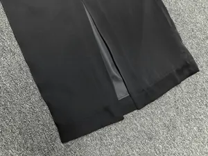 Detail view of black satin skirt hem with center slit and smooth lining craftsmanship