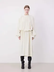 Detail of off-white long sleeve dress with pleated neckline and drawstring waist