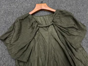 Detail of olive green blouse featuring pleated fabric texture and butterfly sleeves