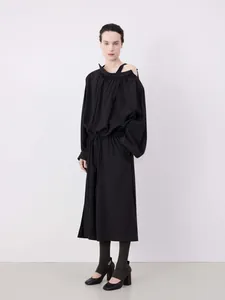 Detail of off-shoulder pleated neckline and drawstring waist on black loose midi dress