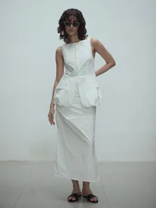 Completo bianco minimalista con top senza maniche, grandi tasche e gonna lunga abbinata