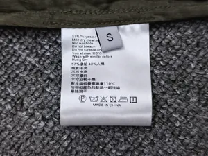 Detailed close-up of the size S garment label showing 57% polyester and 43% rayon materials