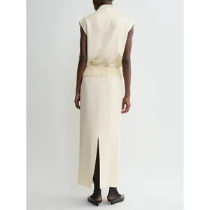Minimalist cream satin sleeveless top and long skirt with tassel waist and back slit