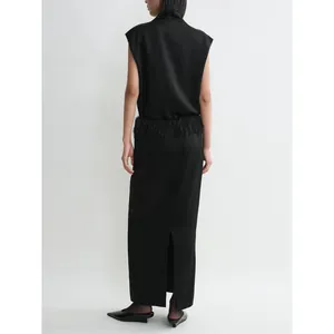 Minimalist black satin skirt set featuring a high neck top and feather tassel hem details