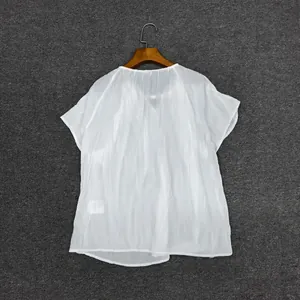Close-up of translucent white short-sleeve top showing textured fabric and round neck detail