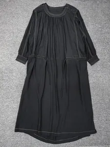 Detail of black long sleeve dress featuring white contrast stitching and drawstring waist