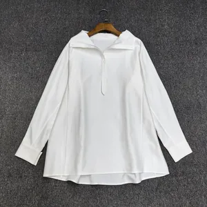 Close-up of the semi-placket button details and stand collar on this white cotton shirt