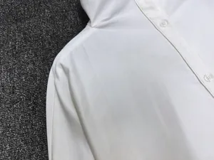 Close-up of white semi-open collar shirt showing detailed cotton twill fabric and buttons