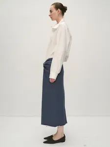 Side view of white long sleeve shirt paired with navy blue maxi skirt for an elegant look