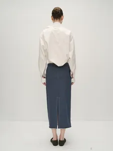 Rear view of loose white shirt and navy midi skirt with back slit detail and minimalist fit