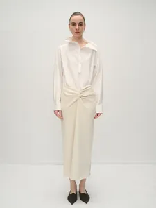 Minimalist white asymmetric collar shirt paired with a creamy pleated long skirt