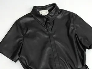 Nahaufnahme von schwarzem mattem Lederkleid-Kragen mit einreihiger verdeckter Knopfleiste