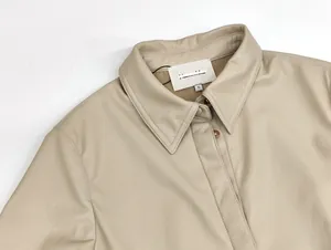 Detailansicht eines beigen Lederkleidkragens mit hochwertigen Nähten und Knöpfen
