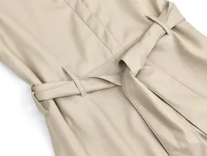 Detailansicht eines beigen Lederkleides mit Gürtel und feinen Nähten an der Taille