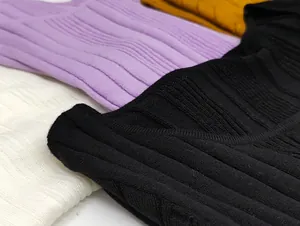 Close-up of ribbed texture on slim-fit knitted tops in black, cream, purple, and yellow