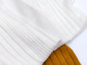 Detail of premium ribbed knit fabric in white and ginger showing texture and elasticity