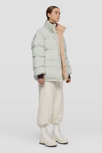 Dettaglio del piumino oversize verde menta con collo alto a contrasto e ampie tasche
