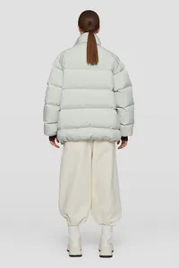 Vista posteriore del piumino trapuntato grigio chiaro minimalista oversize con collo alto