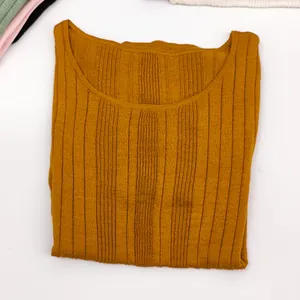Detail view of the ginger yellow ribbed knit texture on this casual crew neck top