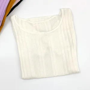 Flat lay of rib-knit crewneck top showing textured vertical lines and color options