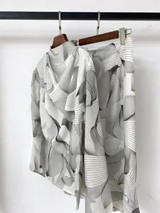 Close-up of lightweight chiffon fabric featuring black abstract linear leaf patterns