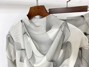 Detail of artistic abstract pattern on lightweight cream long-sleeve hooded top