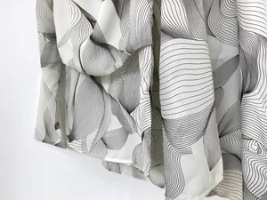Detailed view of lightweight ivory fabric featuring abstract black wavy line patterns