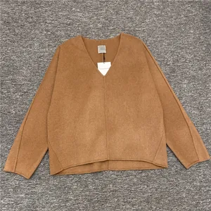 Close-up of minimalist camel double-faced wool top with V-neck and structural seams