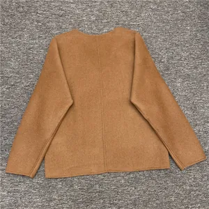 Detail of camel wool jacket back seam with smooth texture on grey textured background