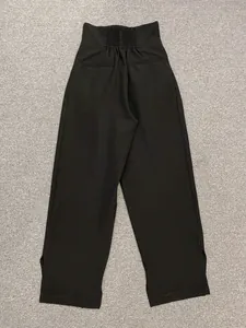 Detail of high waist trousers showing back smocked elastic waistband and side slit cuffs