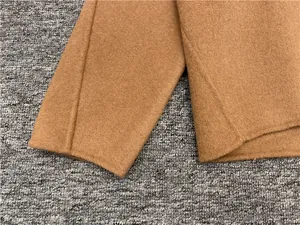 Macro detail of dark camel double-sided wool fabric and stitching on a loose sweater