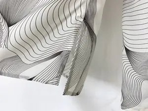 Close-up of black and white wavy print top showing side slit hem detail and fine stitching