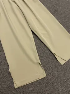 Detail shot of wide-leg trousers showing side slit and sharp front creases