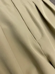 Detailed view of high-waist khaki trousers showing premium stitching and fabric texture