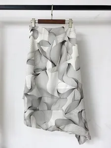 Detail of high-waist irregular skirt with black and white abstract print and asymmetric hem
