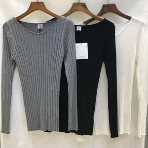Detail of ribbed knit long sleeve tops in grey black and white with V-neckline texture