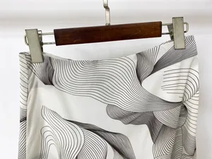 Detail of white printed skirt showing wave patterns and smooth woven fabric texture