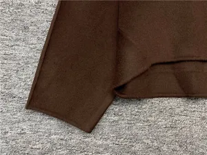 Close-up of premium double-faced wool fabric texture on minimalist dark brown top