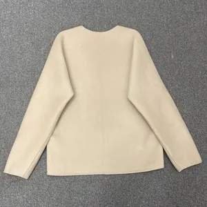 Back view of a minimalist cream wool jacket showing fine texture and center seam detail