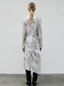 Rear view of long sleeve print top and asymmetric wrap skirt with wave patterns
